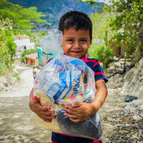 boy holding a bag of FMSC food bags