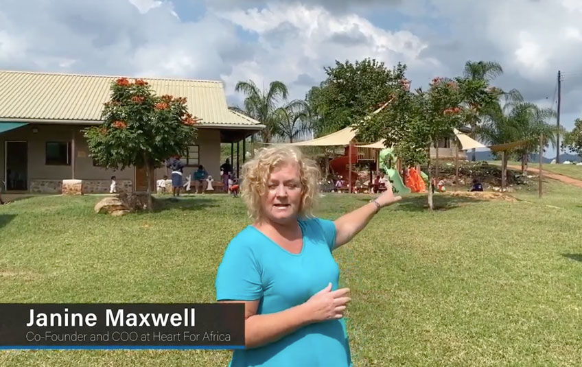 Janine Maxwell of Heart for Africa stands in the grass in front of a building in Eswatini