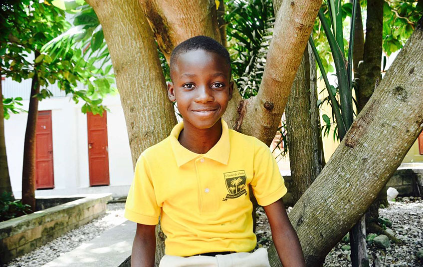 a smiling boy in a yellow shirt