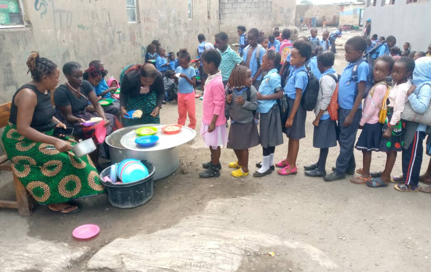 Kids waiting in line to be served food at Free Baptist Community School 