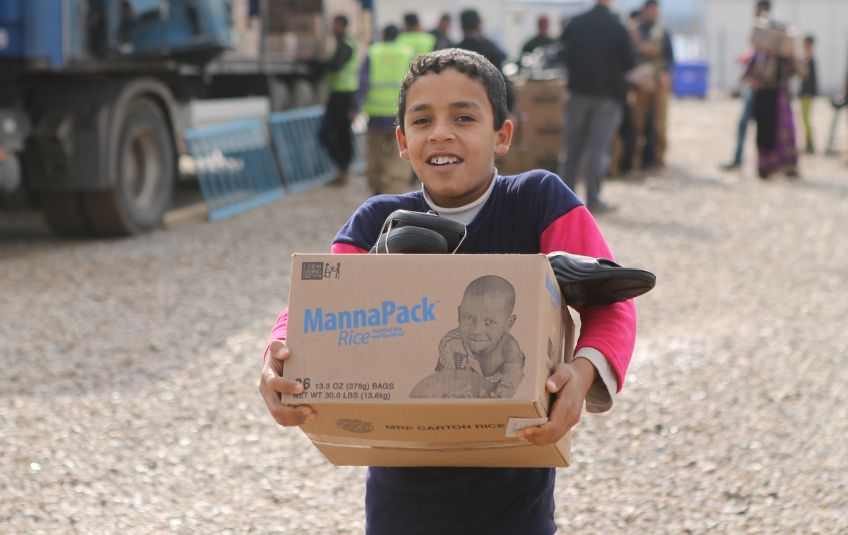 Child in refugee camp with MannaPack box.
