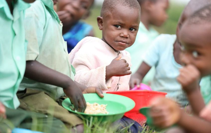 Kids with bowls of food in Uganda. 