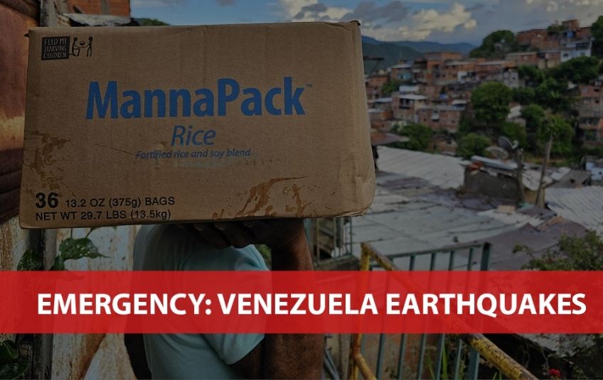person carrying box of FMSC MannaPack meals overlooking scene in Venezuela