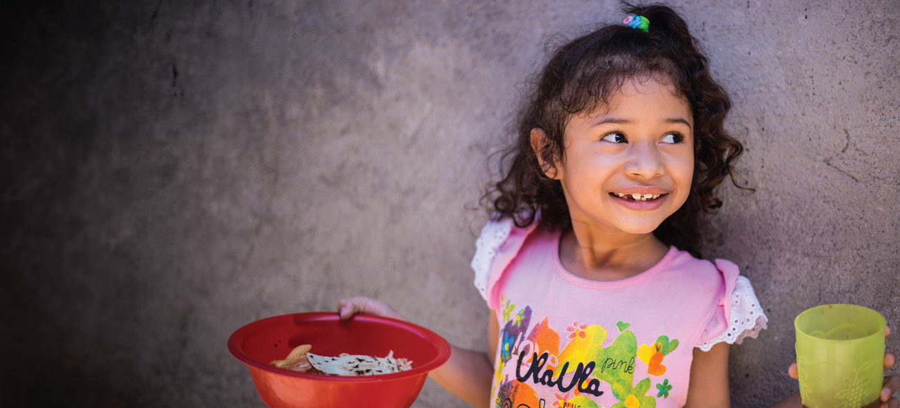 Girl holding a bowl of FMSC food